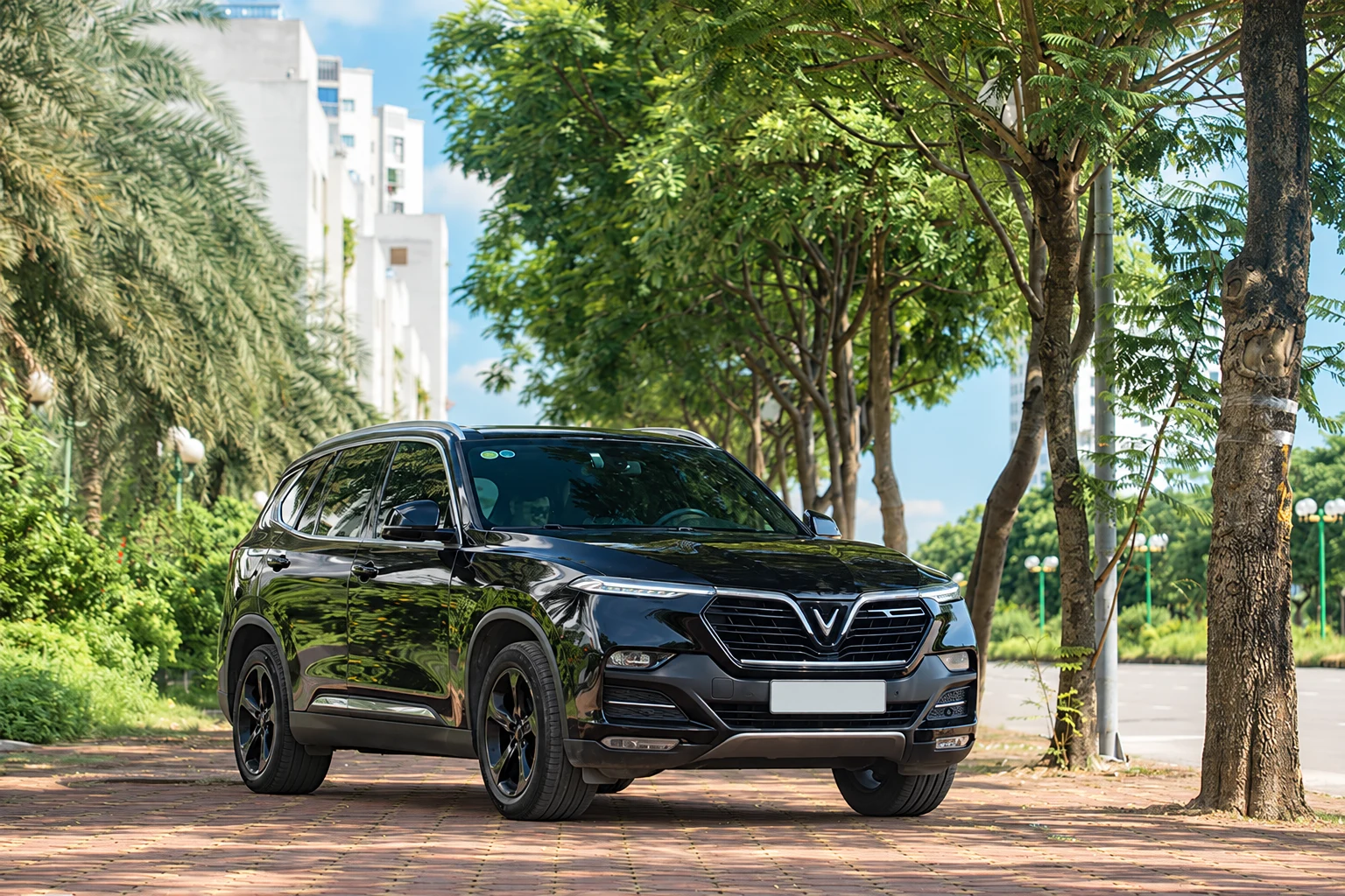 Black VinFast SUV parked on a tree-lined street